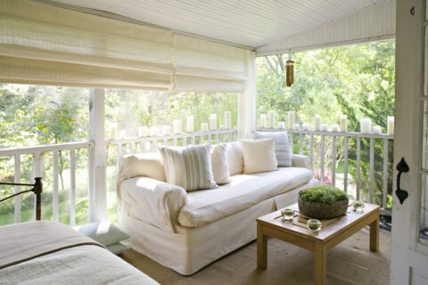 covered porch with sofa and coffee table on a nice spring day