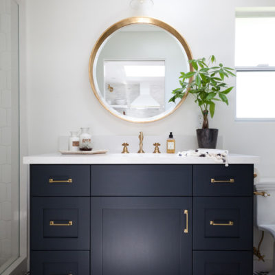 modern bathroom with black cabinets and round mirror