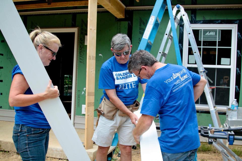agents working with habitat for humanitey building a home