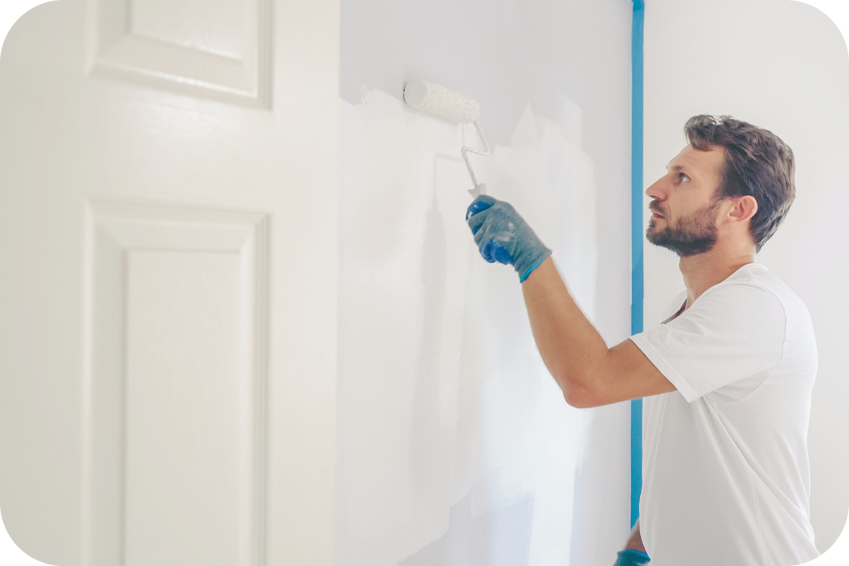 A professional painter applying a fresh coat of neutral paint to a Stafford, VA home as part of the Coldwell Banker Elite Show Ready program.